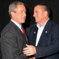 Two middle aged white men shaking hands very close together