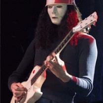Guy playing guitar with Kentucky Fried chicken bucket on his head, he has white makeup like a mime