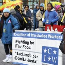 People outside in the cold and rain holding a Fighting for Fair Food sign