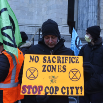 Protestor holding sign saying No Sacrifice Zones, Stop Cop City