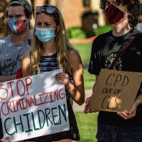 People holding signs saying Stop Criminalizing Children