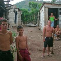 Cuban family standing outside small makeshift house