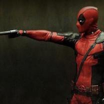 Deadpool character pointing a gun at a teddy bear