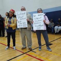 Esther and Gary Witte and Winie Wirth holding signs