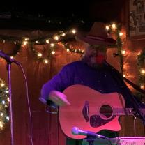 Guy in Cowboy hat playing a guitar