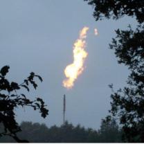 Long shot of firey emission out of smokestack