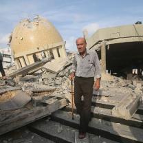 Man in front of destroyed buildings