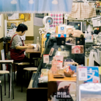 Person working at a desk in a shop filled with arts and crafts
