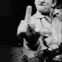 Guy making a mean face holding a guitar and giving us the middle finger