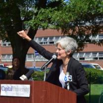 Jill Stein raising her fist at the podium