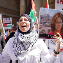 Woman protesting and holding photo of Shireen