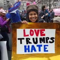 Young woman holding Love Trumps Hate sign