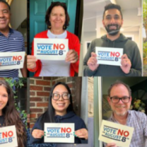 People holding signs saying Vote No on Issue One