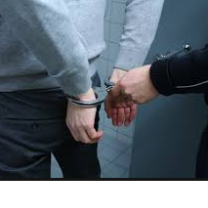 Back of white man with white cop hand putting handcuffs on him