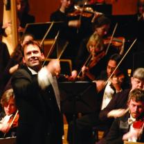 Man in front of orchestra conducting