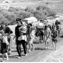 Families walking down a road with all their belongings