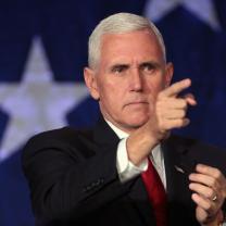 Very serious looking white haired white man pointing in a menacing way