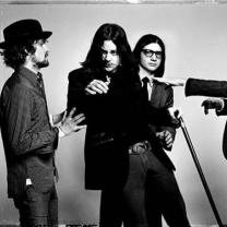 Black and white photo of four white guys in a band with suits on posing like they are moving around funny