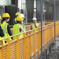 People in hard hats walking through facility