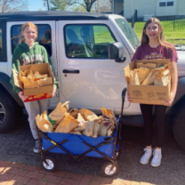 People posing with sack lunches