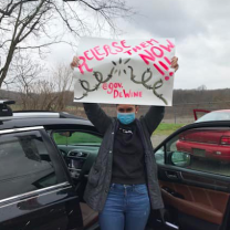 Woman holding a sign saying Release Them Now