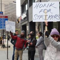 People outside striking with signs