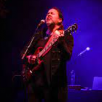 Guy singing with guitar on stage