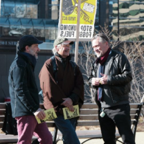 Three men talking outside at a protest