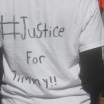 The back of a person wearing a white T-shirt that says Justice for Timmy!!