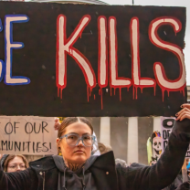 Woman with ICE Kills sign