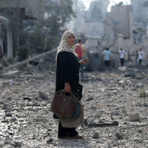 Woman in Gaza street with devastation all around