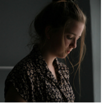 Young white woman in a side view as she looks down