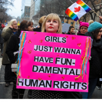 Women marching and young blonde woman holding a pink sign that says Girls Just Want to Have Fun-damental Rights