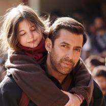 Man carrying a little girl on his back 