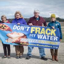 Four people holding a Don't Frack My Water sign