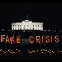 PHoto of white house with neon lights in front against black saying FAKE CRISIS NO WALL