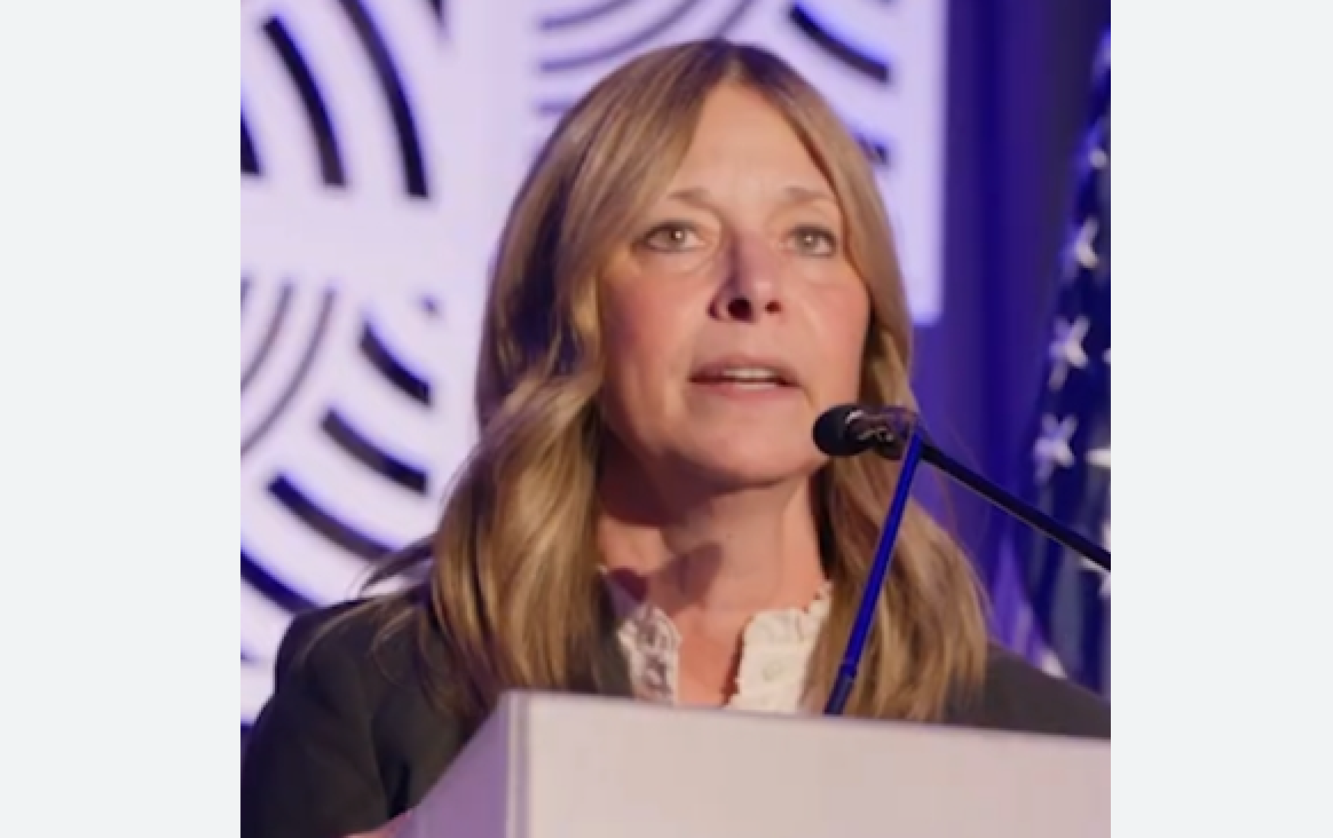 White woman at a podium