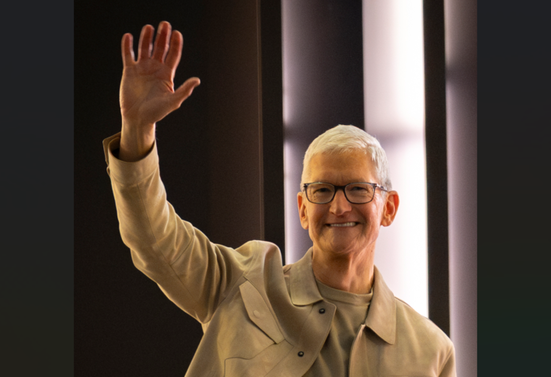 Older man raising his hand and smiling