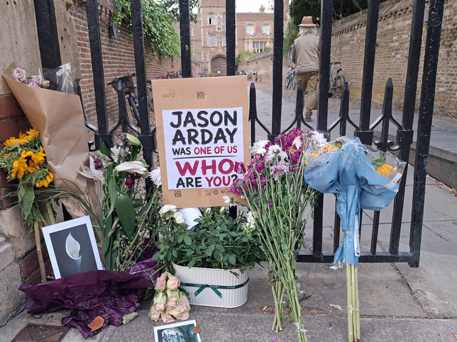 Memorials with flowers and a sign about Jason Arday